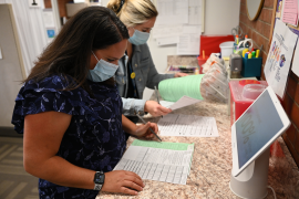 Nurses in mask stare at records